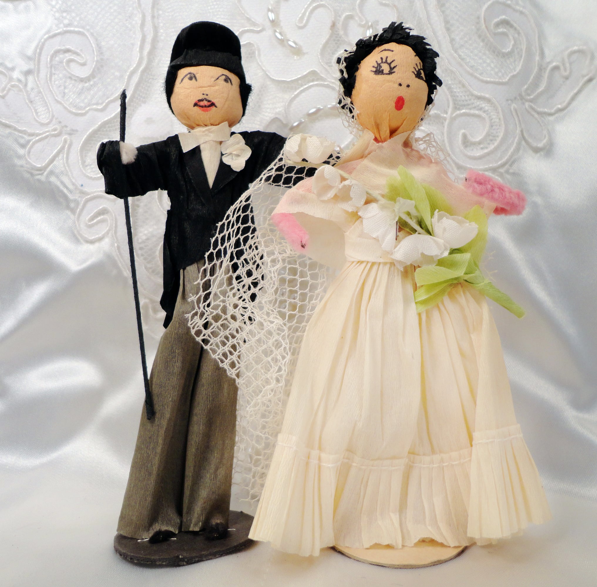 Wonderful facial features highlight this crepe paper pair, circa 1930. Marked “A Reed Product, C.A. Reed—Williamsport, PA.” Groom 5-1/2”. $175-$200/pr.