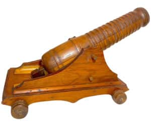 Large antique handmade carved Folk Art model cannon sculpture featuring a pivoting barrel that has a spring-loaded fillet/knob. Measures 17 1/2 inches long by 10 3/4 inches tall by 9 1/4 inches wide.
